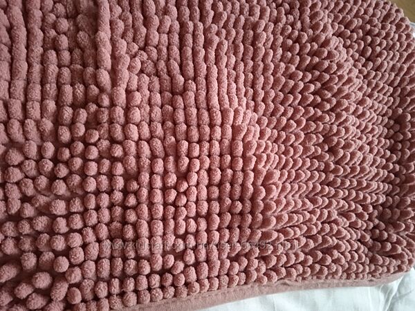 Два темно рожевих килимка у ванну кімнату.